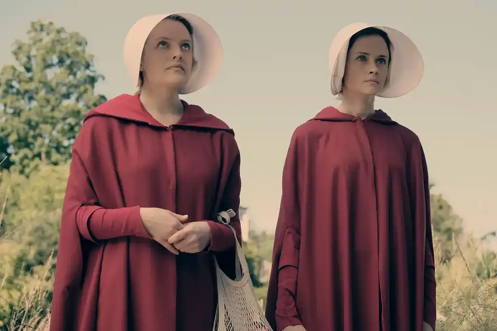 Two handmaids dressed in striking red robes
