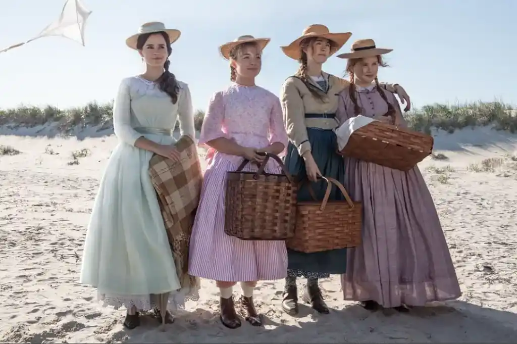 The March sisters stand together at a beach